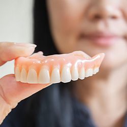 Woman holding dentures