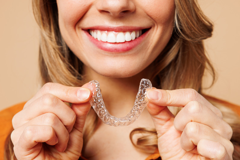 Patient smiling with their Invisalign aligner